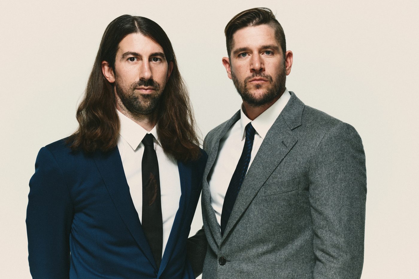 Close portrait in suits, deadpan