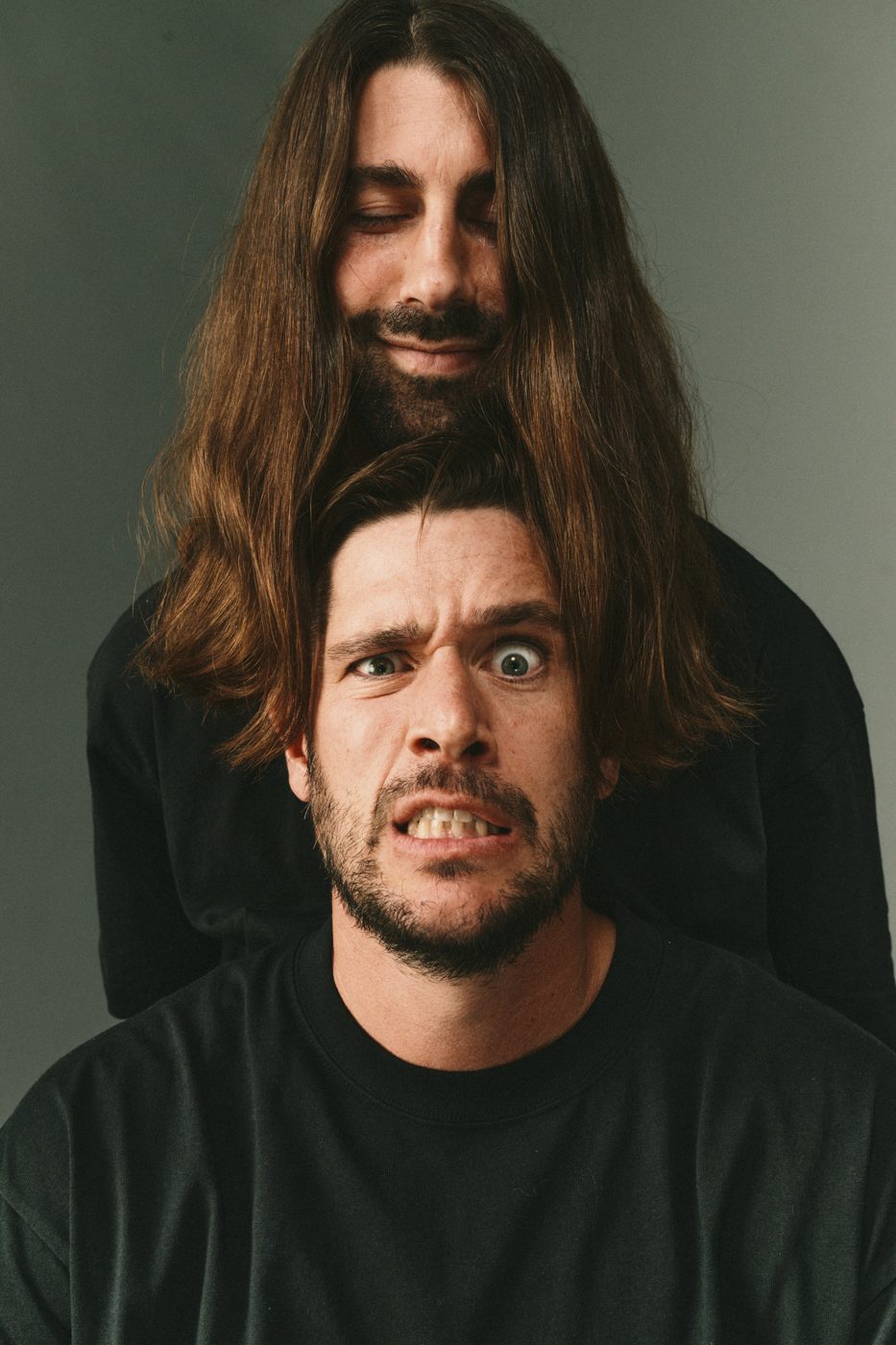 Long hair draped over a grimacing face