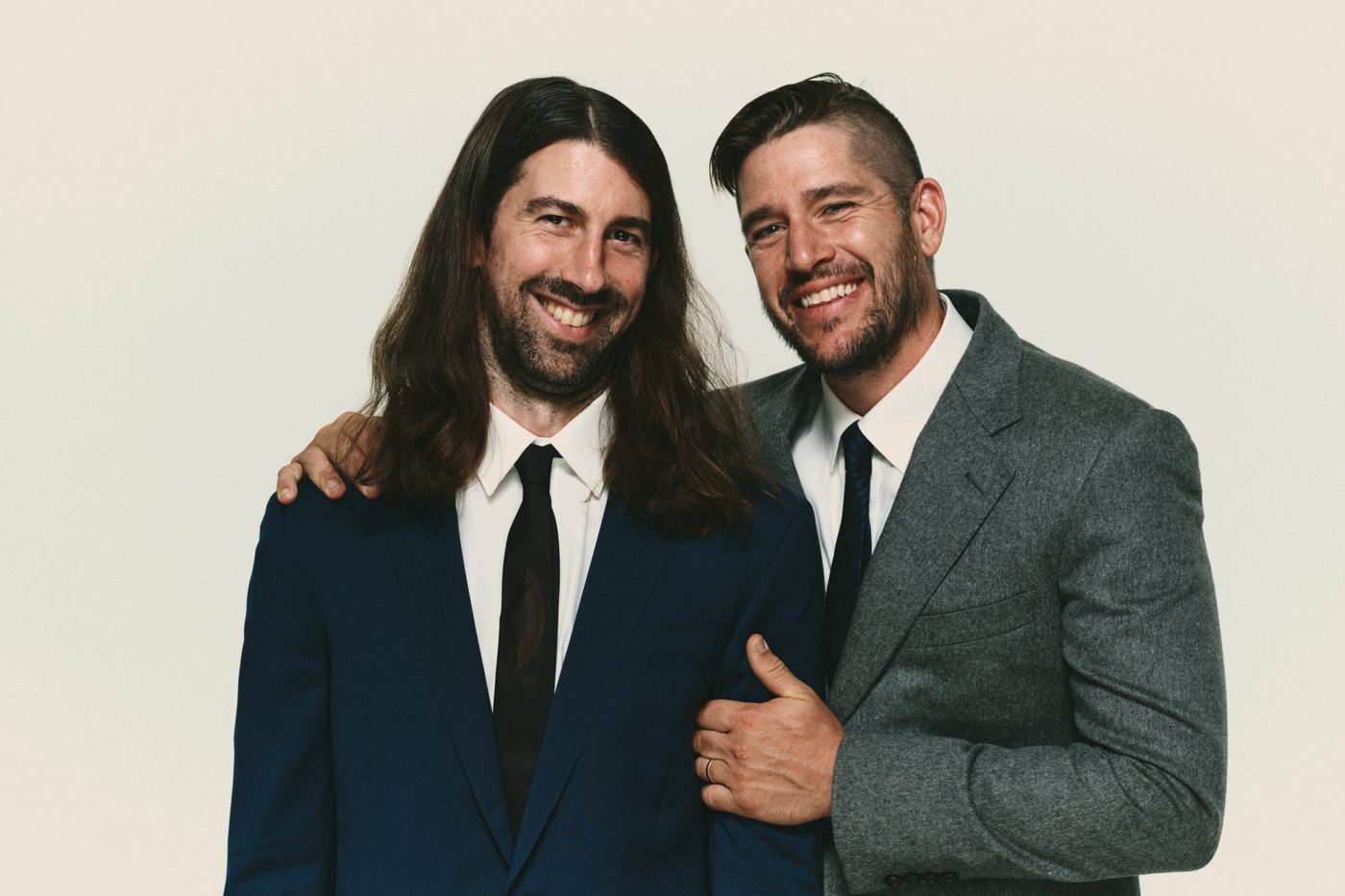 Close portrait in suits, both laughing