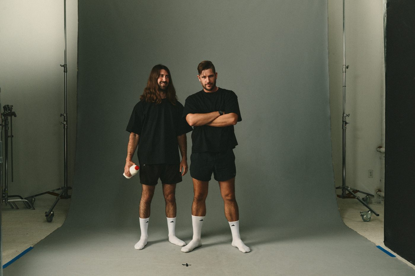 Black tees, black shorts, white socks, arms crossed